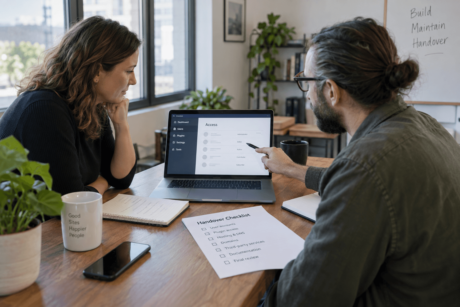 Two colleagues reviewing website access during a handover.